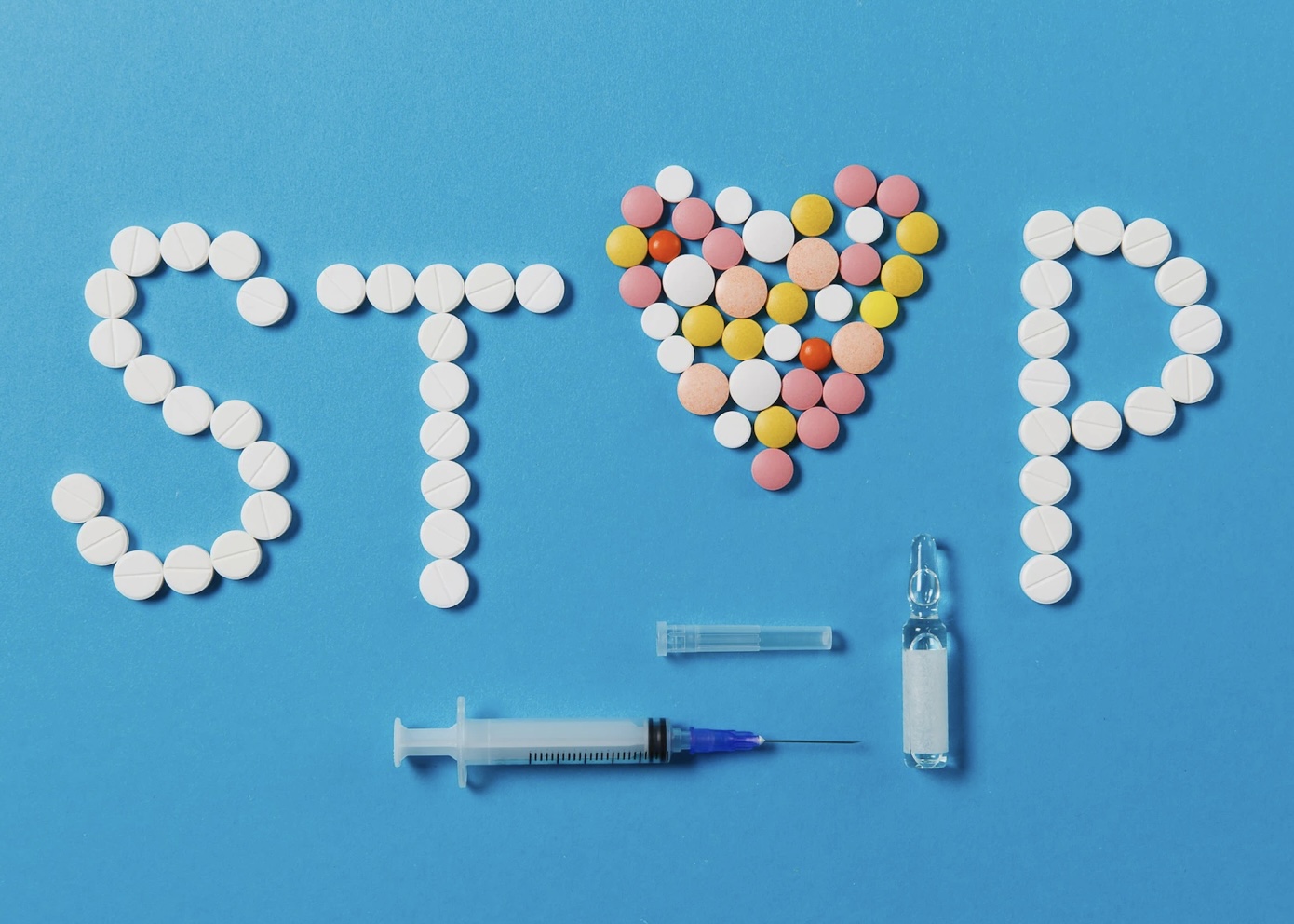 Image showing several recreational drugs in form of pills and injectable formulations. It highlights the message to stop using drugs for better health and shows that drug usage causes bruxism.
