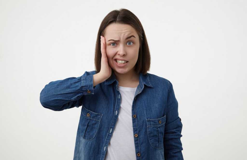 Girl having severe muscle, jaw pain due to teeth grinding